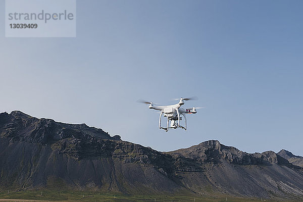 Niedrigwinkelansicht einer Drohne  die gegen Berge und klaren Himmel fliegt