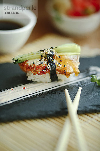 Nahaufnahme von Sushi  das mit Stäbchen auf dem Tisch im Restaurant serviert wird