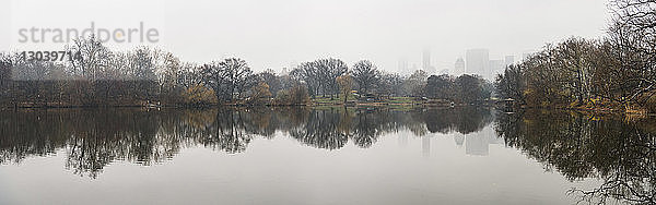 Panoramablick auf den See bei kahlen Bäumen gegen klaren Himmel im Winter