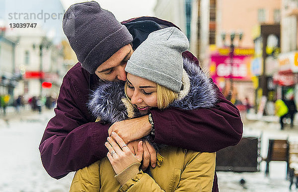 Glückliches Paar umarmt sich auf der Straße der Stadt