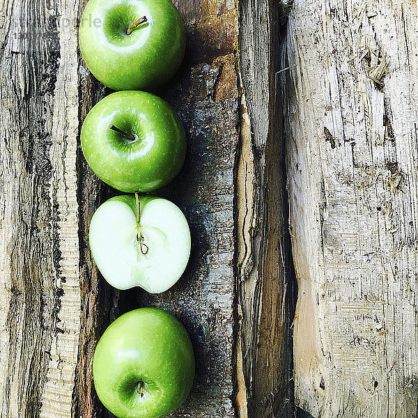 Draufsicht auf Granny-Smith-Äpfel  die auf einem zerbrochenen Tisch angeordnet sind