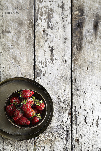 Draufsicht auf Erdbeeren in Schale auf Holztisch