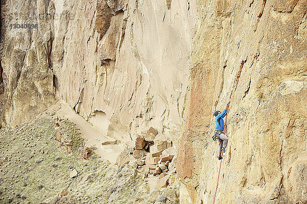 Hochwinkelaufnahme eines männlichen Bergsteigers beim Bergsteigen