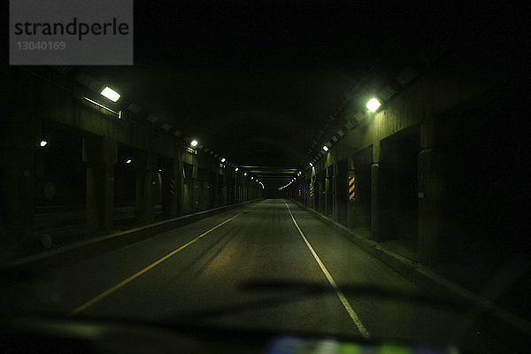 Beleuchteter Tunnel durch die Windschutzscheibe eines Autos gesehen