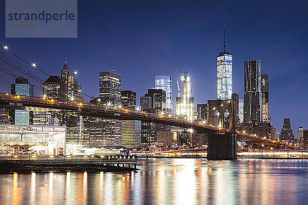 Brooklyn Bridge über den East River gegen den Himmel in der Stadt in der Abenddämmerung