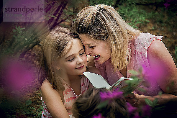 Hochwinkelansicht einer glücklichen Mutter und Tochter beim Lesen eines Buches