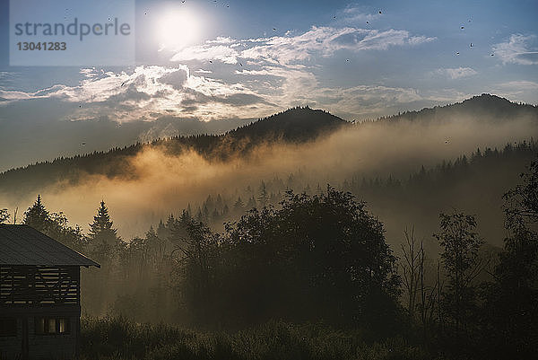 Landschaftliche Ansicht der Berge gegen den Himmel bei nebligem Wetter bei Sonnenaufgang