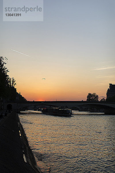 Brücke über den Fluss gegen den Himmel bei Sonnenuntergang