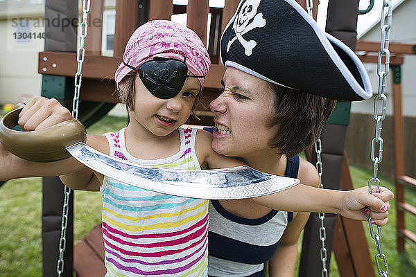 Mutter und Tochter in Piratenkostümen spielen auf dem Spielplatz