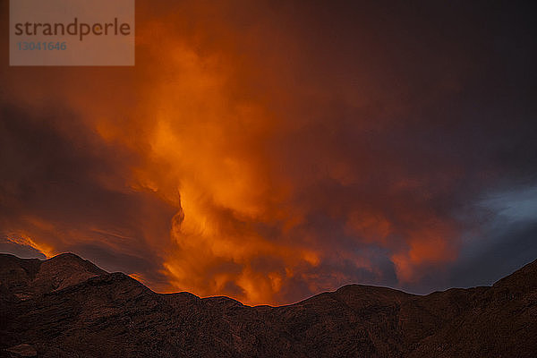 Landschaftliche Ansicht des Berges gegen orangefarbenen Wolkenhimmel bei Sonnenuntergang
