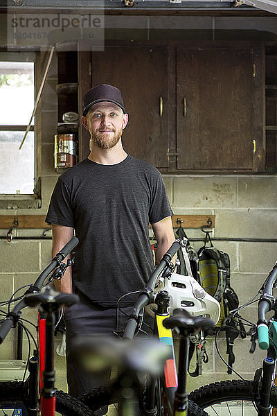 Porträt eines selbstbewussten Mechanikers  der im Fahrradladen steht