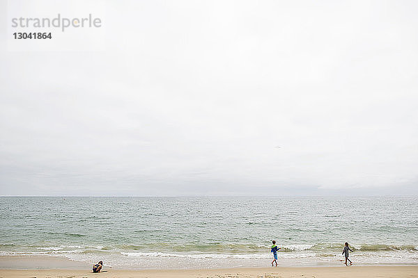 Geschwister spielen in Seal Beach gegen klaren Himmel