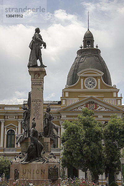 Niedriger Blickwinkel der Statue gegen das Parlamentsgebäude