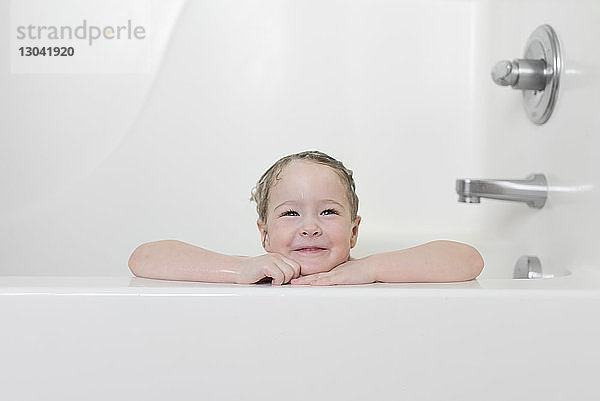 Lächelndes Mädchen sitzt in der Badewanne