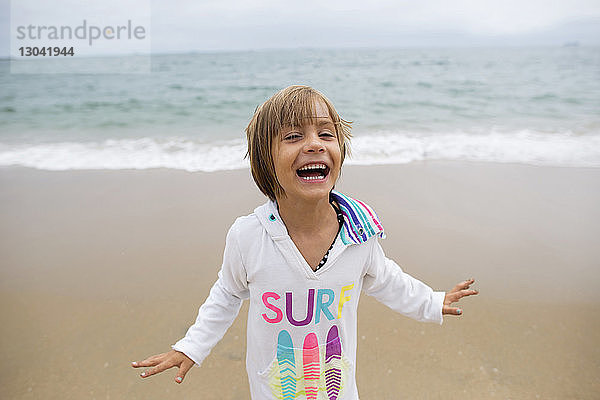 Fröhliches Mädchen steht am Ufer von Seal Beach