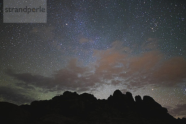 Szenische Ansicht einer Silhouetten-Felsformation vor einem nächtlichen Sternenfeld