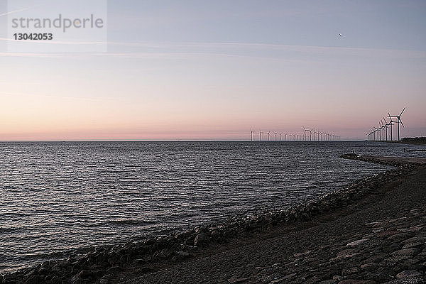 Scherenschnitt Windmühlen auf dem Meer gegen den Himmel bei Sonnenuntergang in Urk
