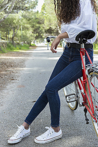 Niedriger Abschnitt einer Frau mit Fahrrad auf der Straße
