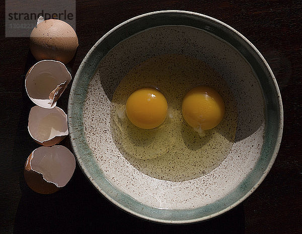 Draufsicht auf zerbrochene Eier in der Schale nach Schalen auf dem Tisch