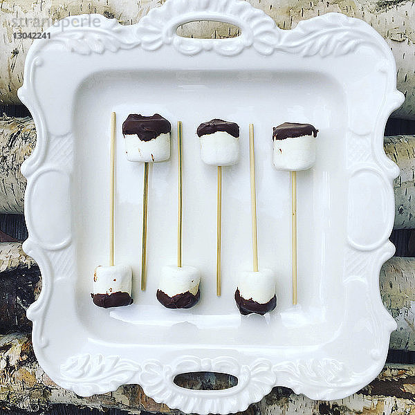 Draufsicht auf in Teller auf dem Tisch arrangierte Schokoladen-Marshmallows