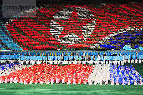 Menschen treten im Rungnado-Mai-Stadion gegen die nordkoreanische Flagge auf