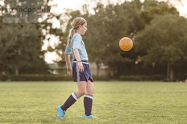 Seitenansicht eines Mädchens beim Fussballspielen auf dem Platz