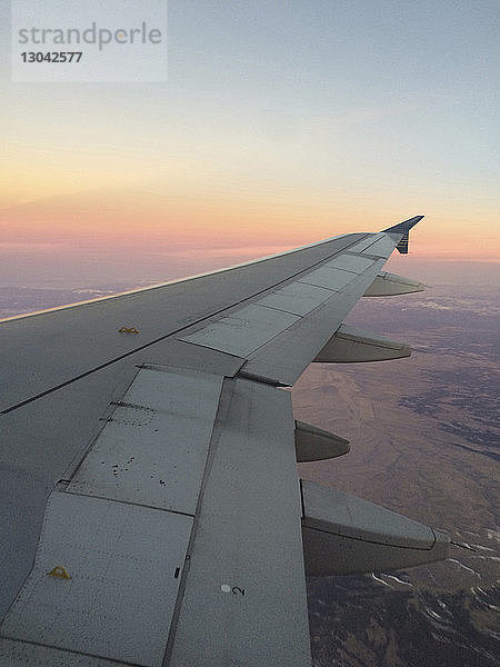 Ausschnittsbild eines Flugzeugs am Himmel während des Sonnenuntergangs