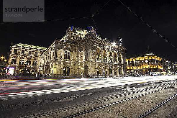 Lichtspuren auf der Straße der Wiener Staatsoper gegen den nächtlichen Himmel