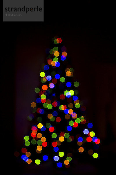 Defokussiertes Bild eines beleuchteten Weihnachtsbaums bei Nacht