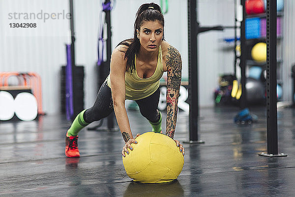 Sportler macht Liegestütze mit Medizinball im Fitnessstudio