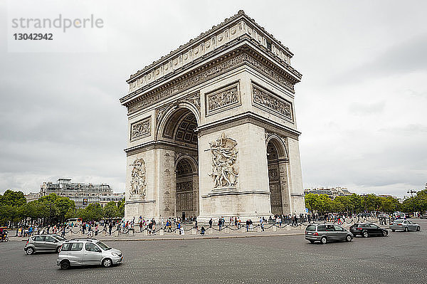 Tourist besucht Arc de Triomphe gegen bewölkten Himmel in der Stadt