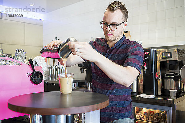 Selbstbewusster Barista macht Kaffee im Café