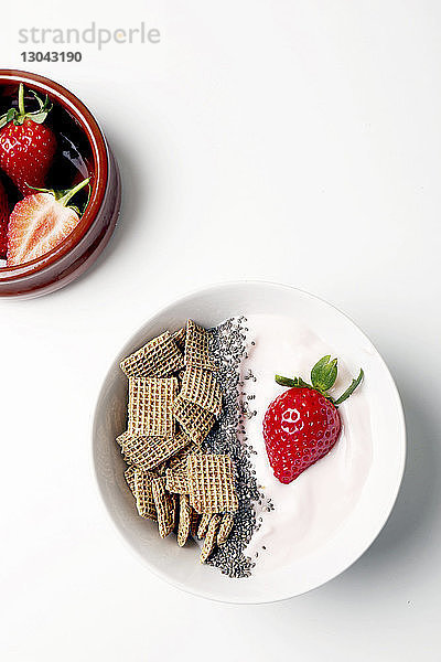 Draufsicht auf das Frühstück mit Erdbeeren auf weißem Hintergrund
