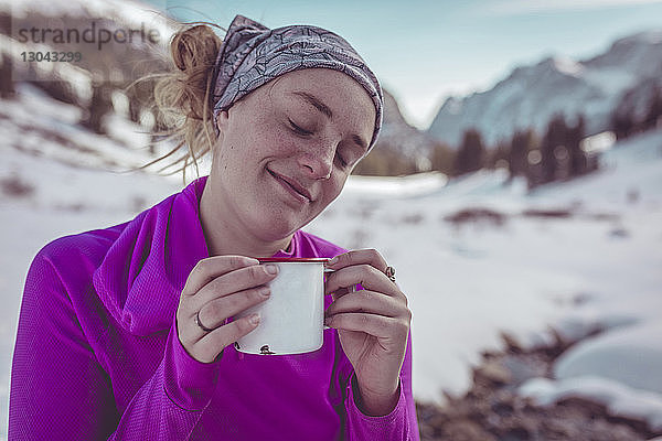 Frau trinkt im Grand-Teton-Nationalpark im Winter beim Entspannen