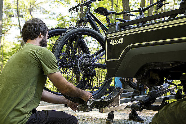 Freunde stellen Mountainbikes auf Geländewagen im Wald ein