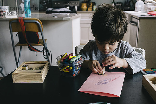 Junge spielt zu Hause mit Stempel