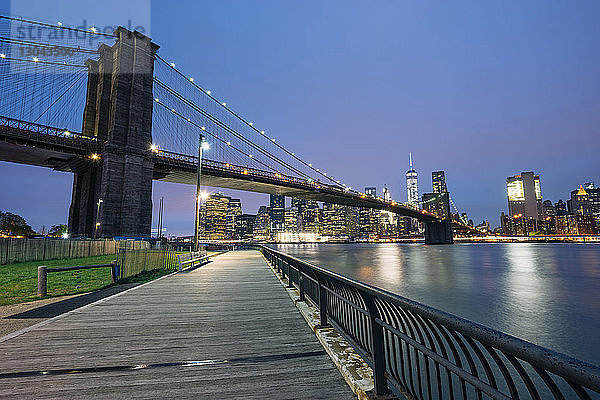 Beleuchtete Brooklyn Bridge und ein Welthandelszentrum gegen den nächtlichen Himmel