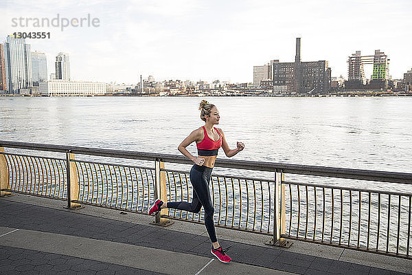 Weibliche Athletin läuft auf der Promenade am East River