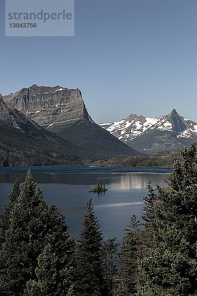 Panoramablick auf See und Berge vor klarem blauen Himmel im Glacier National Park