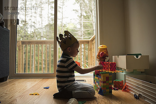 Seitenansicht eines Jungen  der zu Hause mit Spielzeugklötzen spielt