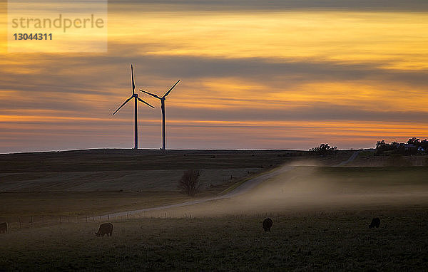 Scherenschnitt Windturbinen auf dem Feld bei Sonnenuntergang