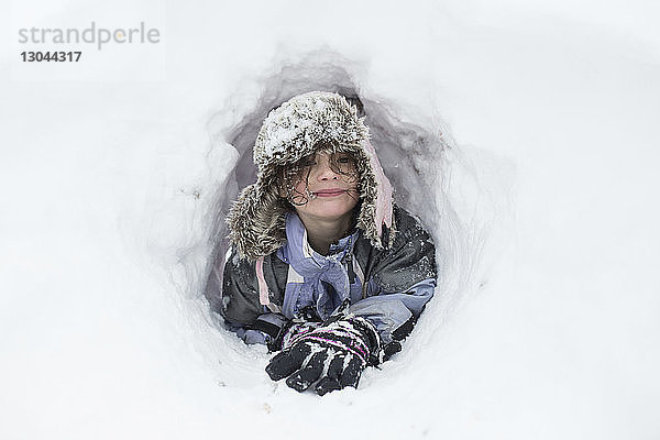 Porträt eines glücklichen Mädchens in schneebedecktem Loch