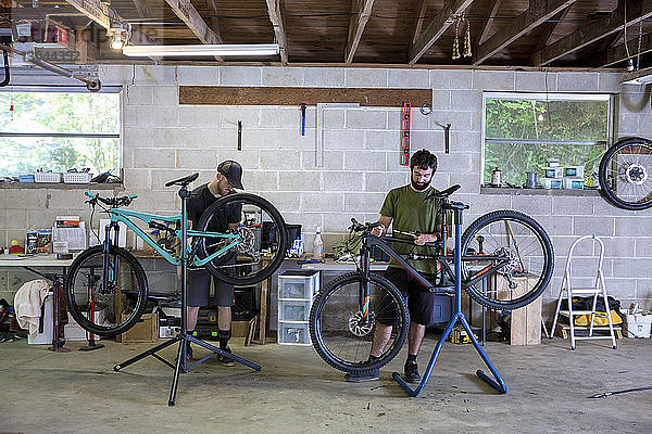 Mechaniker reparieren Mountainbikes im Fahrradgeschäft