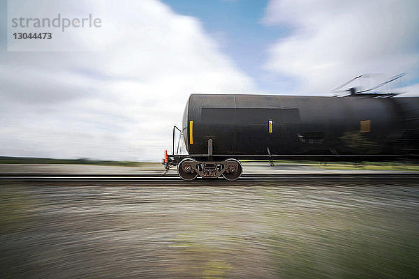 Lagertanks bewegen sich auf Eisenbahnschienen gegen bewölkten Himmel