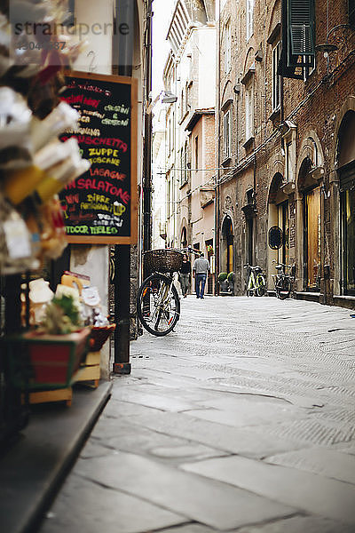 Oberflächenebenes Bild einer Gasse inmitten von Gebäuden in der Stadt