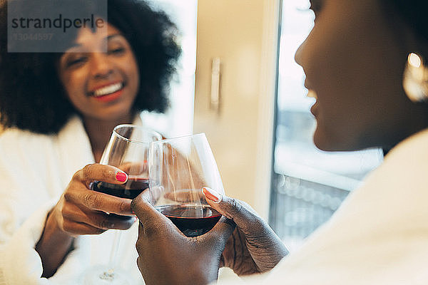 Nahaufnahme von Geschäftsfrauen  die im Hotelzimmer auf Wein anstoßen