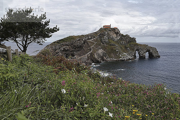 Szenische Ansicht eines Hauses auf einer Insel inmitten des Meeres vor bewölktem Himmel