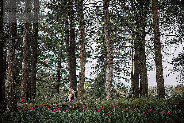 Seitenansicht eines Mädchens  das mitten im Wald steht