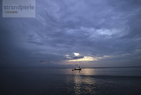 Scherenschnitt-Freunde genießen im Meer gegen bewölkten Himmel