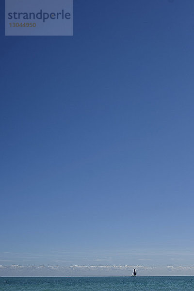 Fernsicht auf ein Segelboot  das im Meer vor blauem Himmel segelt